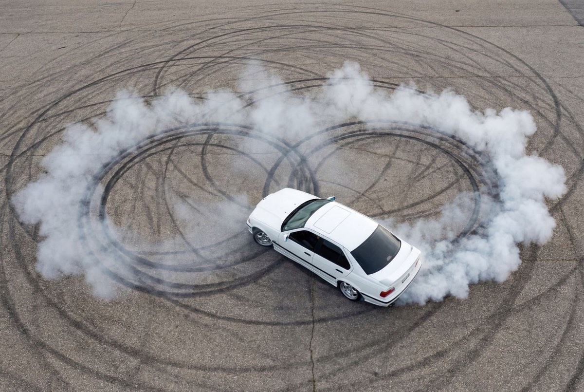 Vista aérea de la BMW E36 haciendo un ocho de drift en la pista