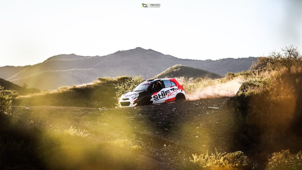 Rally car on a dirt stage with the Córdoba hills in the background
